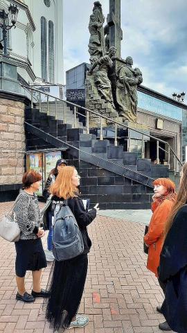 La partoprenantoj de la ekskurso apud la monumento al la lasta rusa caro kaj liaj familianoj